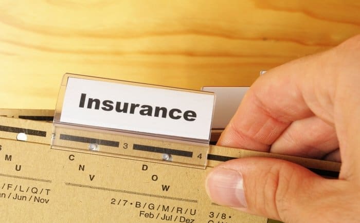 A man holding a folder with an "insurance" tag
