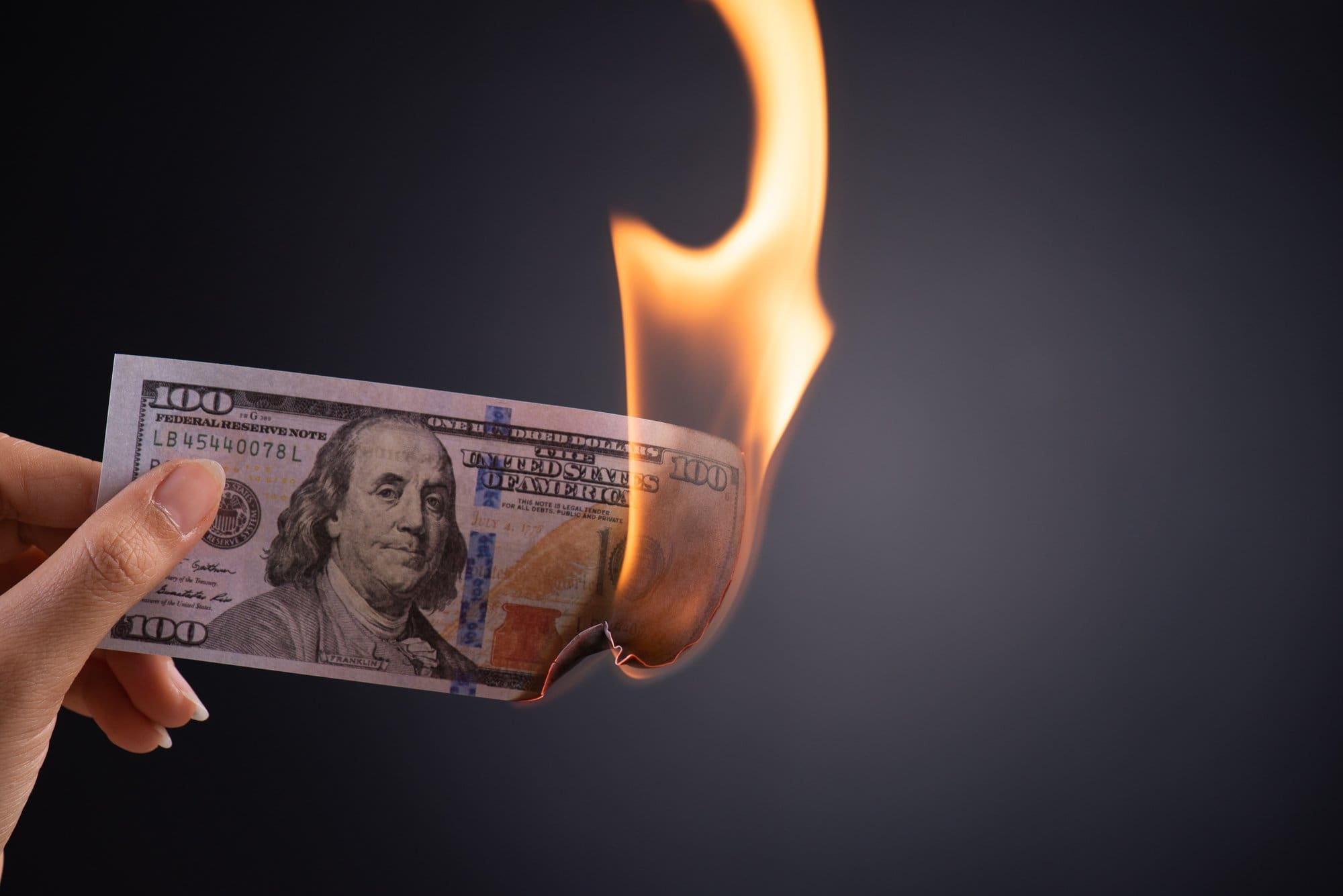 Woman hand holding burning dollar cash