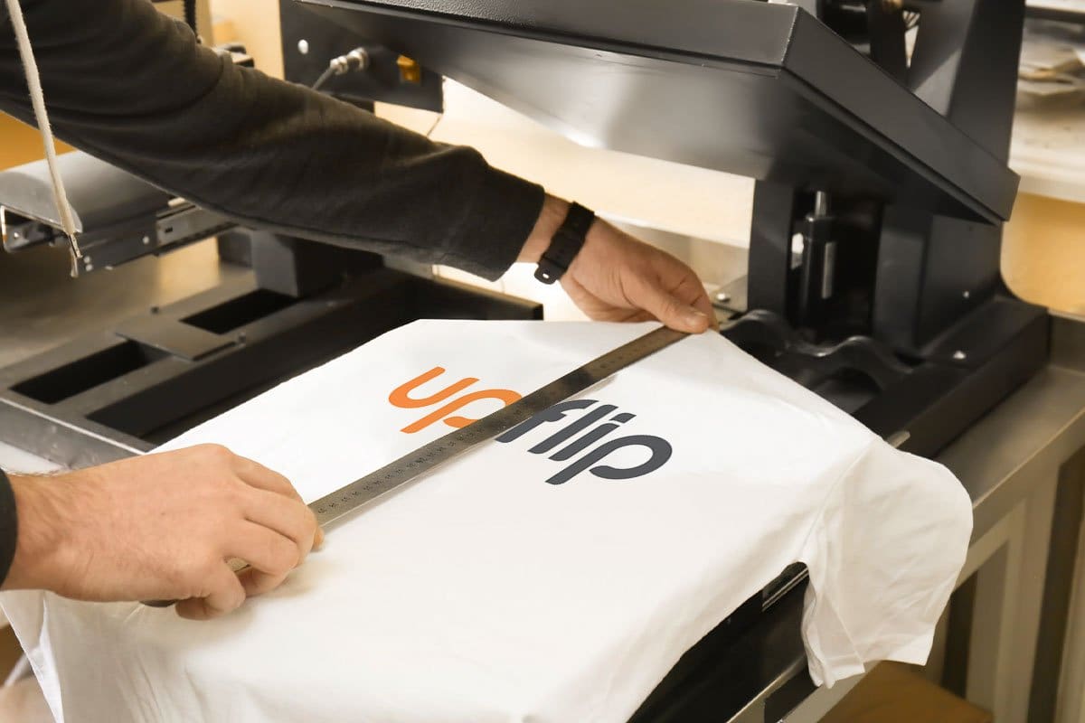 man measures the t-shirt upflip logo on heat press machine