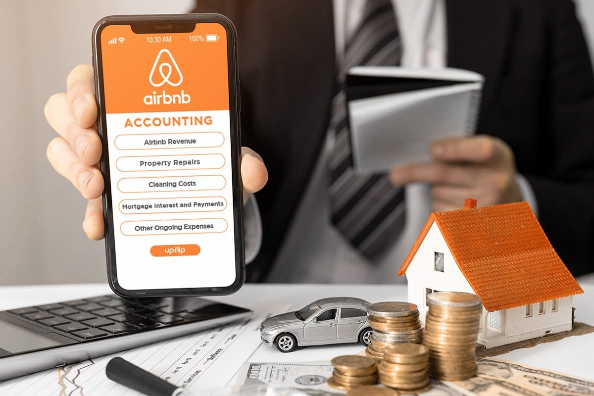 man showing a mobile phone with an airbnb accounting checklist
