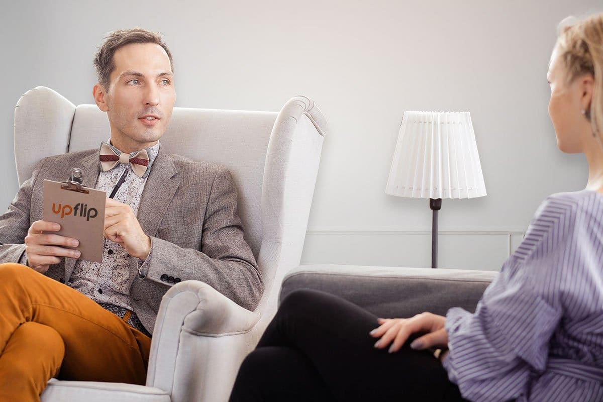 two people sitting on a chair while having a conversation