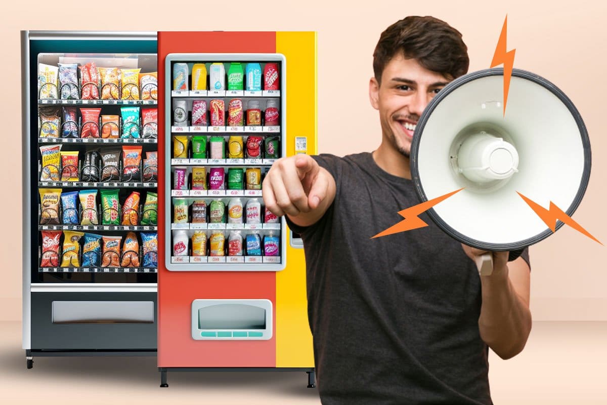 Happy young entrepreneur holding megaphone in front of two vending machines