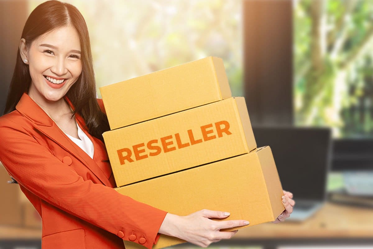 Smiling women in a bright red blazer holding boxes including one marked "Reseller"