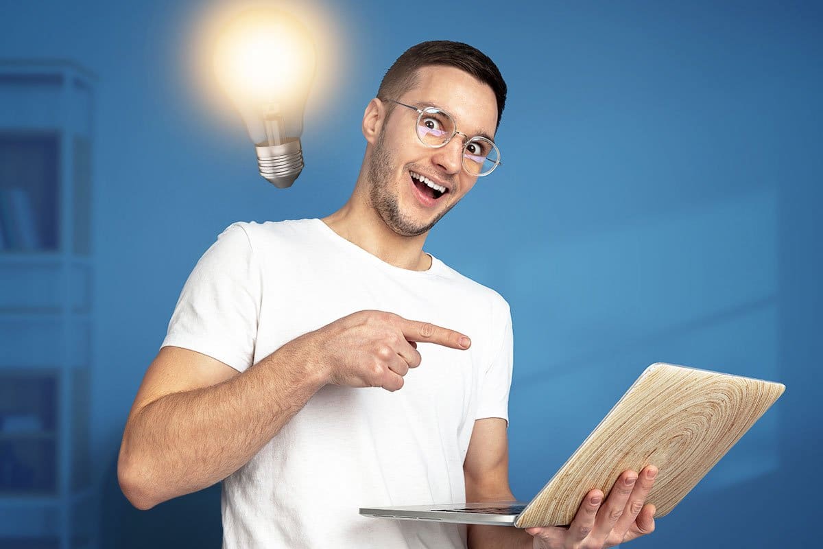 Concept of young man business owner with new idea illustrated by a bright lightbulb over shoulder and laptop in hand