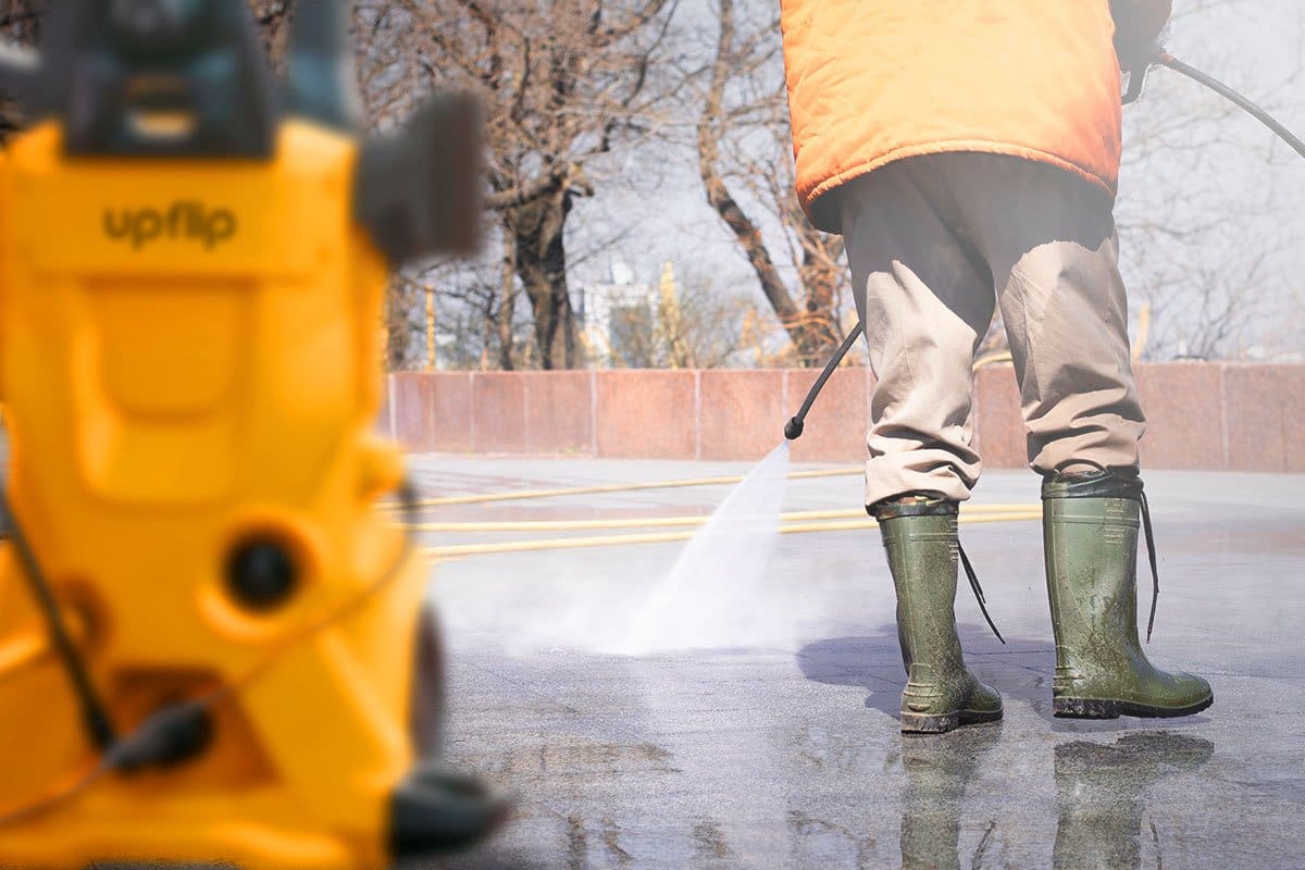 Best Pressure Washer Trailer Setup (2025) 2 Low-angle shot of a power washer using settings to power wash blacktop outside on a sunny day