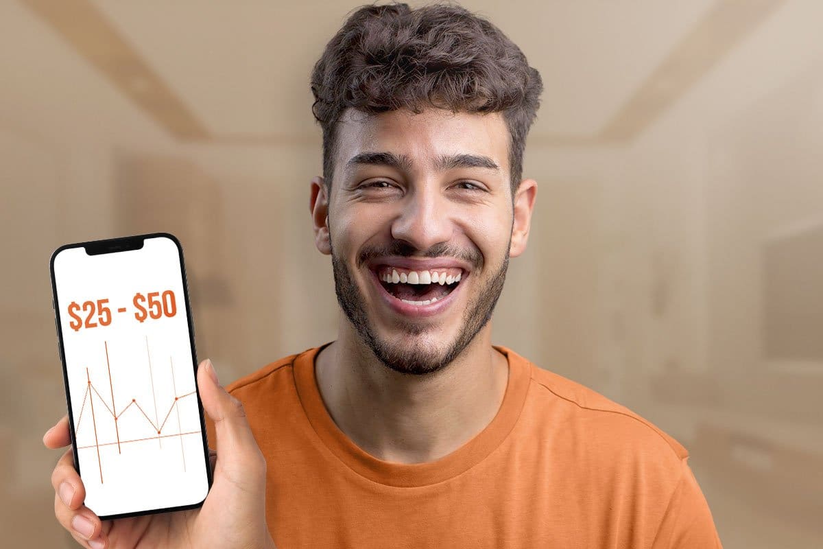 Young man business owner using a smartphone to generate leads shown by text reading "$25 to $50" over a graph on his phone