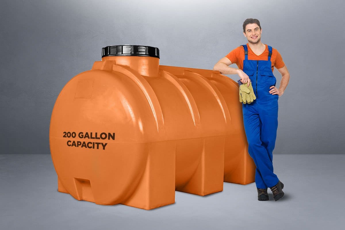 Best Pressure Washer Trailer Setup (2025) 10 Worker wearing coveralls and holding gloves leaning against an orange water tank
