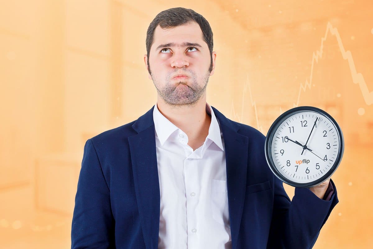How to Start a $15M/Year ATM Business 3 Considering time to ATM profit illustrated by man puffing out his cheeks in frustration while holding an analog clock
