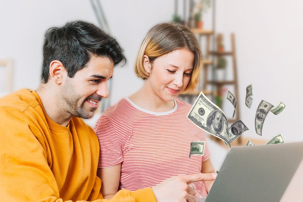 Concept of couple working on a laptop with cash flying out of the screen
