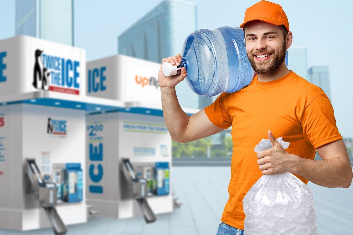 A man in an orange cap holding ice and water in front of Twice the Ice vending machines.