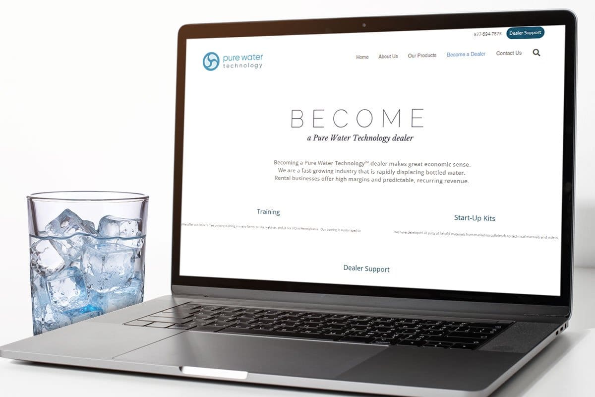A laptop showing a Pure Water Technology webpage about water vending next to a glass of ice water.