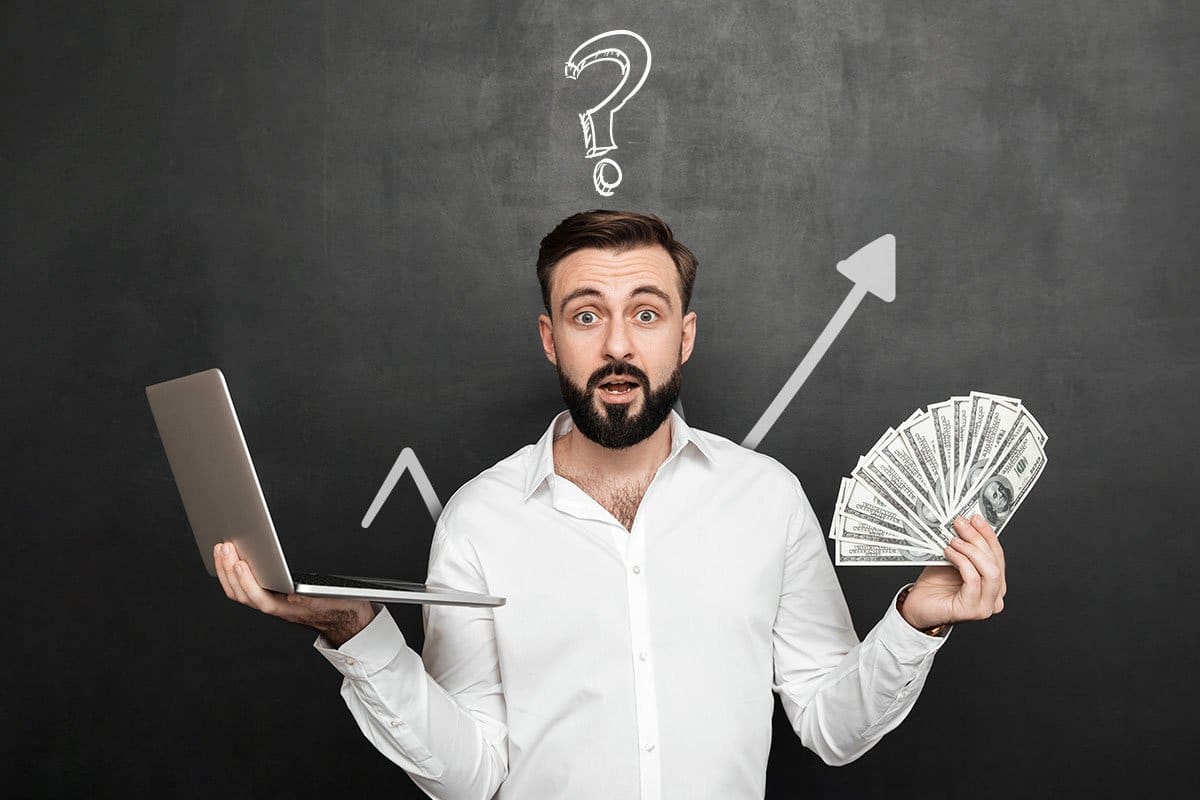 A business owner holding a laptop in one hand and cash in the other with a question mark over his head and a growth arrow in the background.
