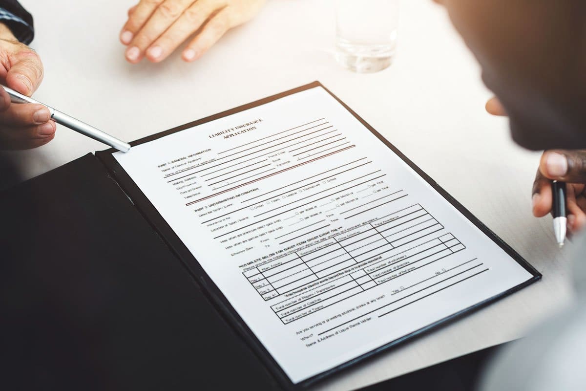 Overhead shot of business people seated at a table reviewing an insurance form