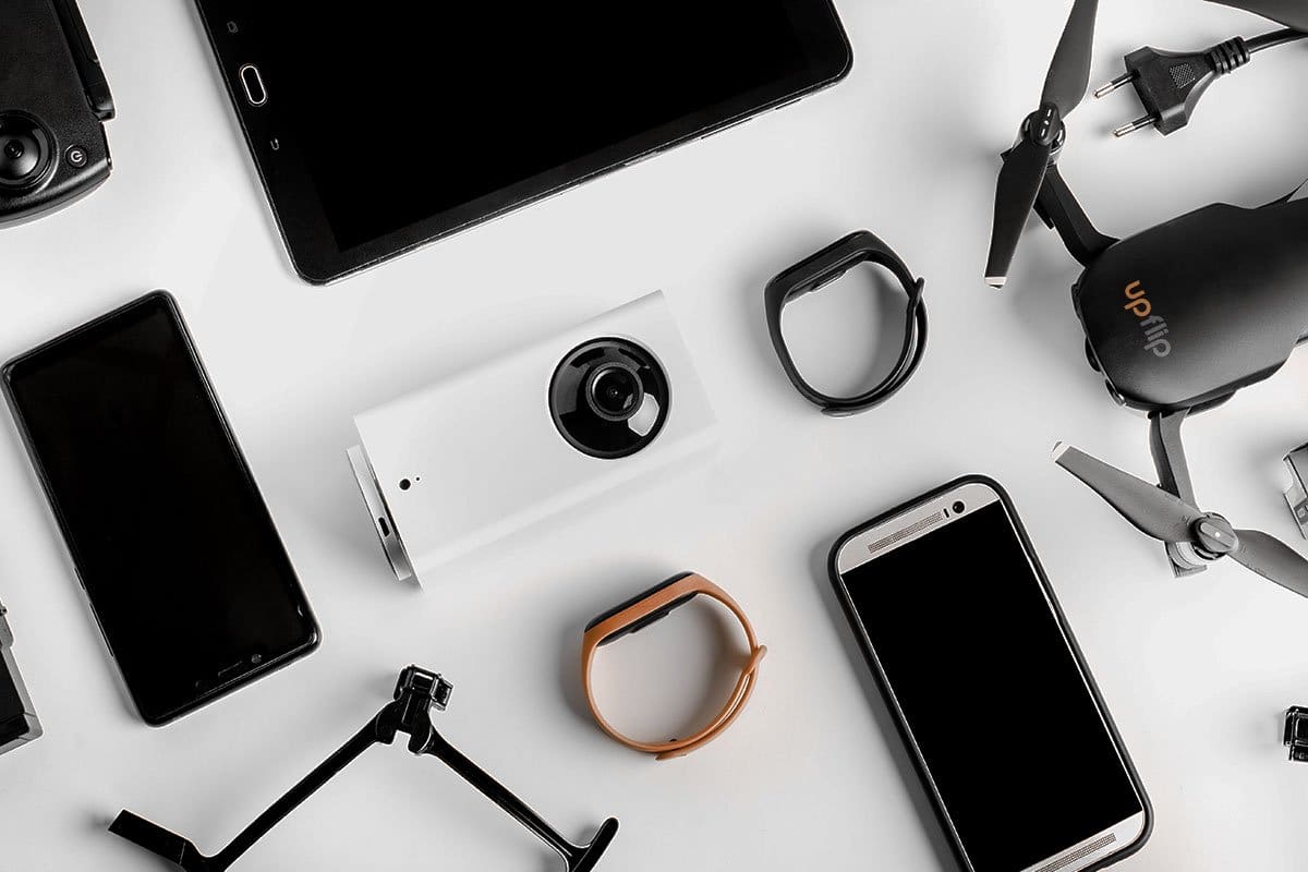 23 eCommerce Business Ideas You Can Start Today 8 Tech gadgets including smart watches, drones, smart phones, and tablets photographed on a white table for listing on an e-commerce-site