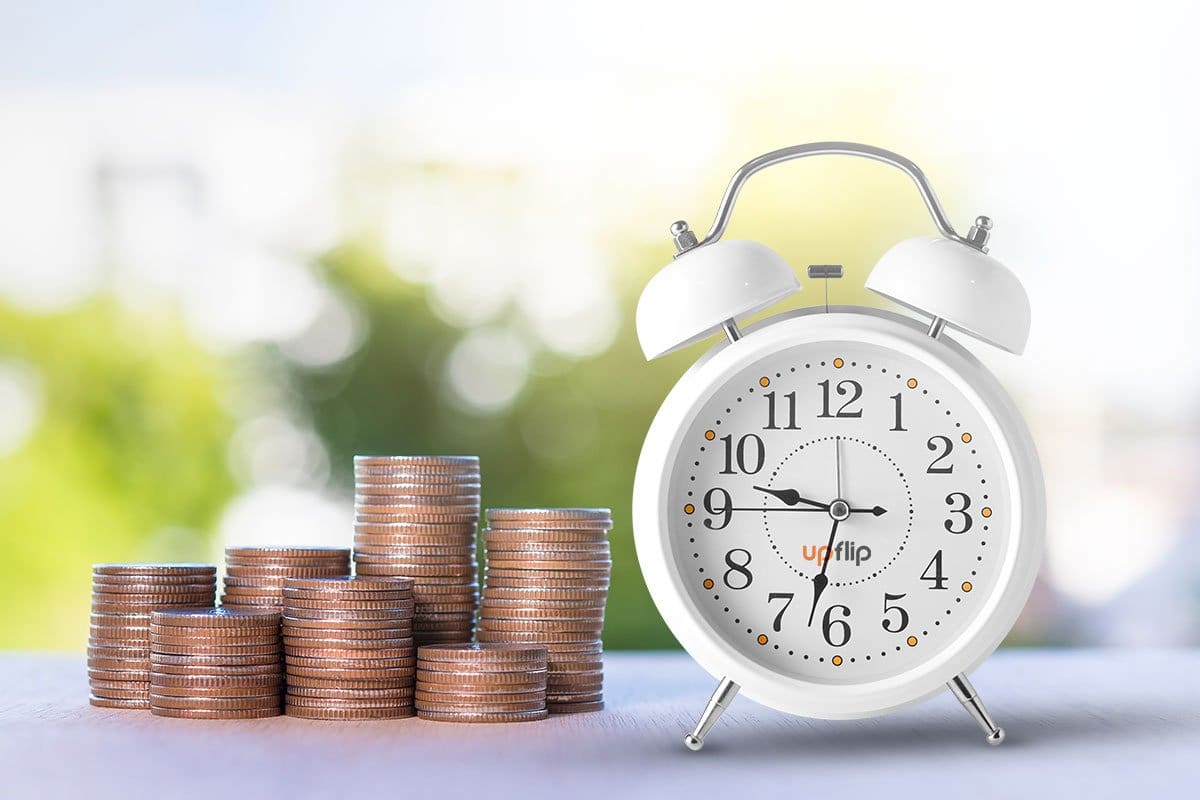 Stacks of quarters next to a white alarm clock