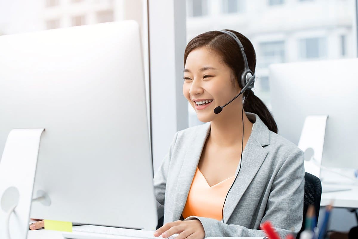 How to Become an Entrepreneur in 13 Steps 18 Customer support professional wearing a headset and working at a desktop computer