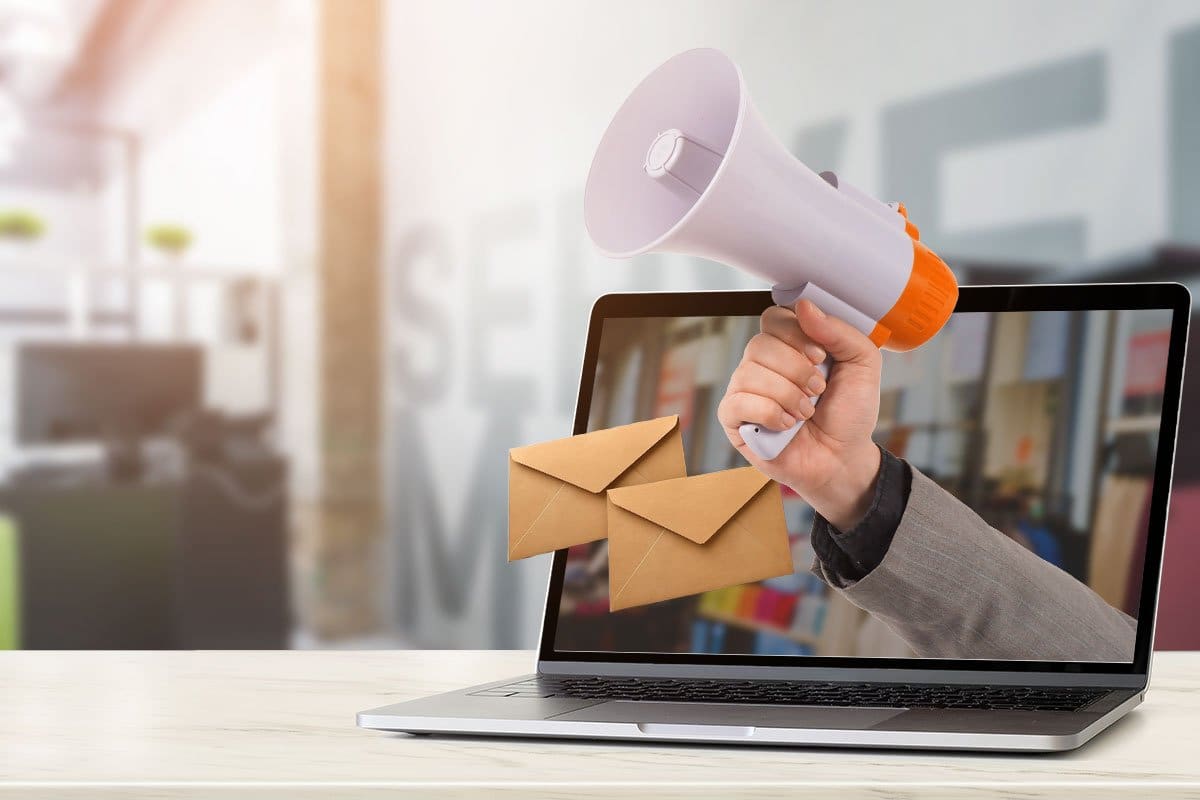 The 11 Best Print-on-Demand Companies of 2025 12 Marketing concept showing a hand with megaphone and two envelopes emerging from a laptop screen