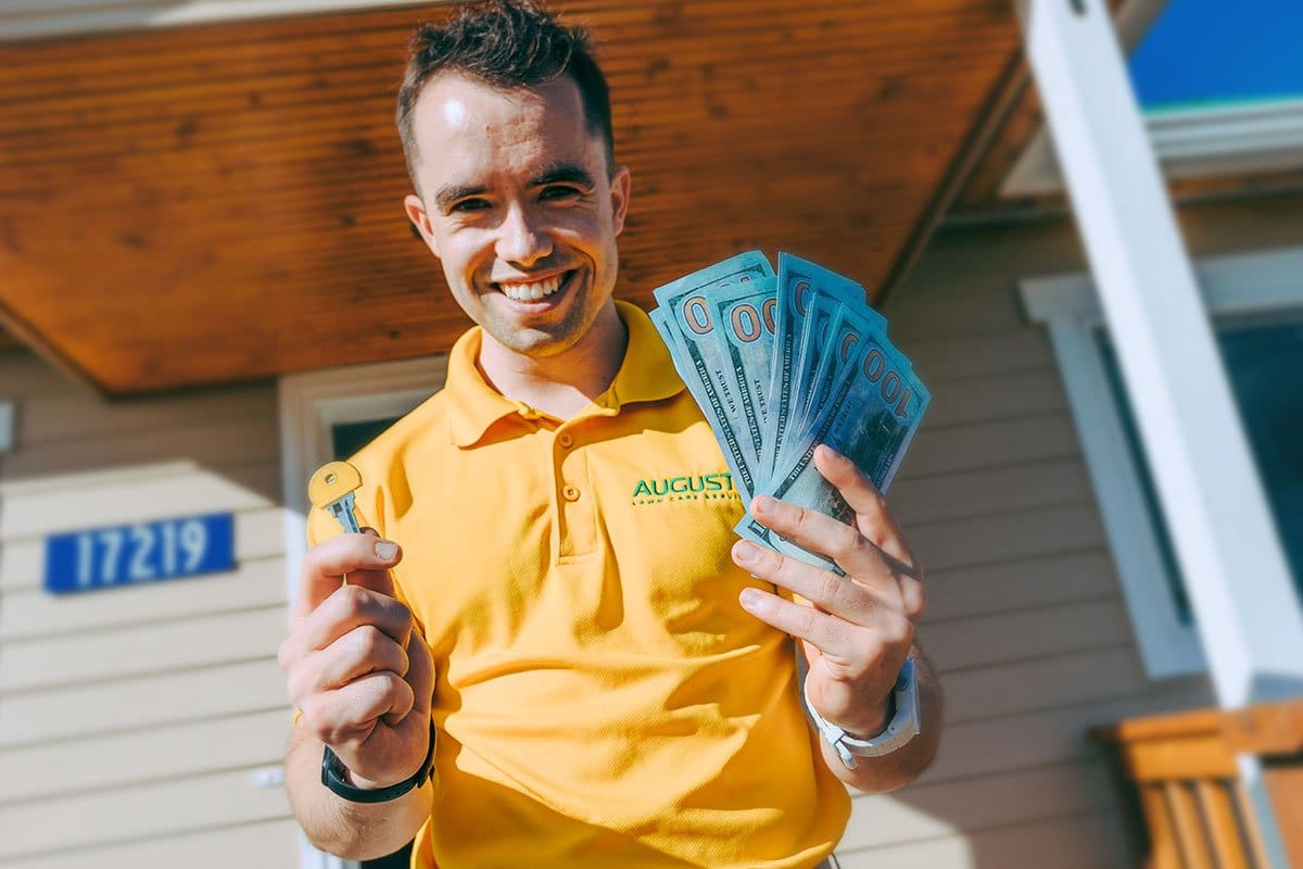 How to Become an Entrepreneur in 13 Steps 10 Mike smiling while holding hundred dollar bills and a house key