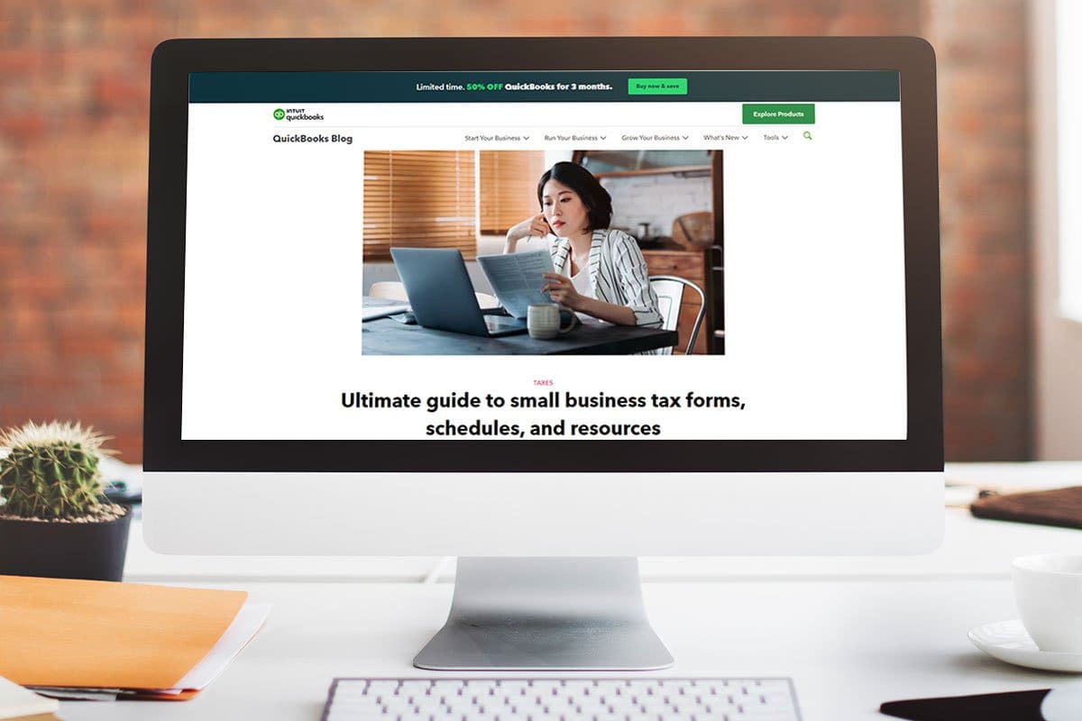 QuickBooks blog post on tax forms, schedules, and resources on a desktop computer