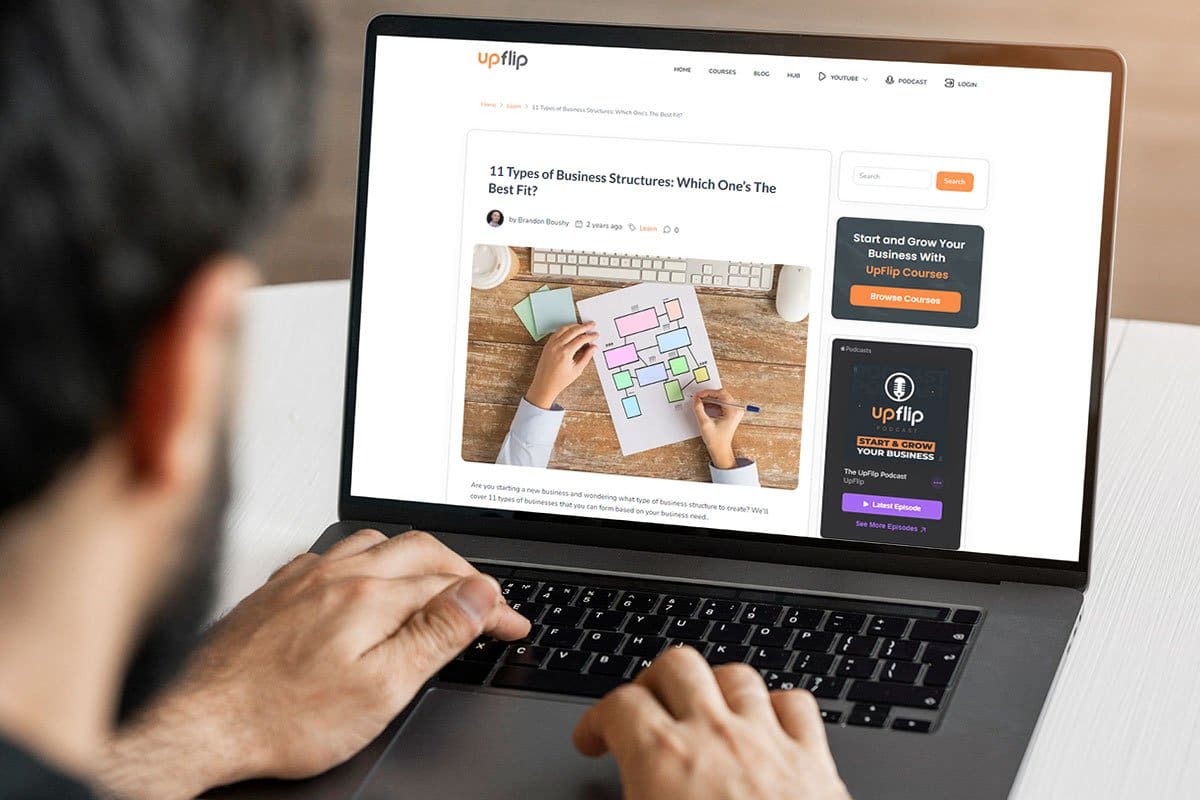 How to Become an Entrepreneur in 13 Steps 9 Man reading UpFlip’s business structures blog post on a laptop