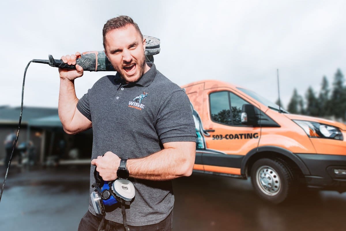 Wise Coatings owner posing with equipment in front of a wrapped work van