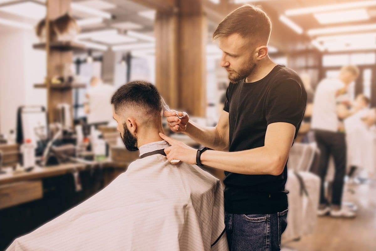 Barbershop owner cutting a man’s hair