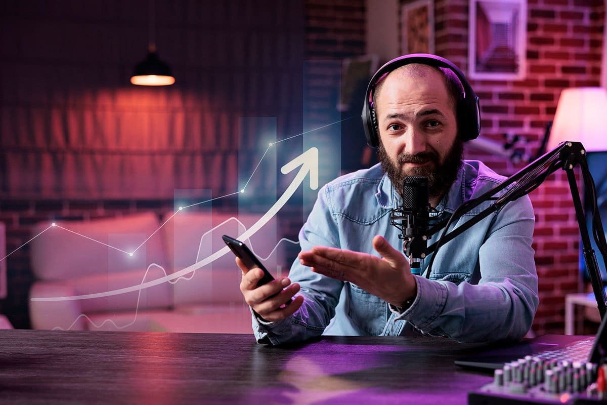 How to Grow a Podcast (2025) 12 Podcaster in a swanky-looking, dimly lit studio gesturing to the smart phone in his hand while an upward trending arrow and graph hover beside him