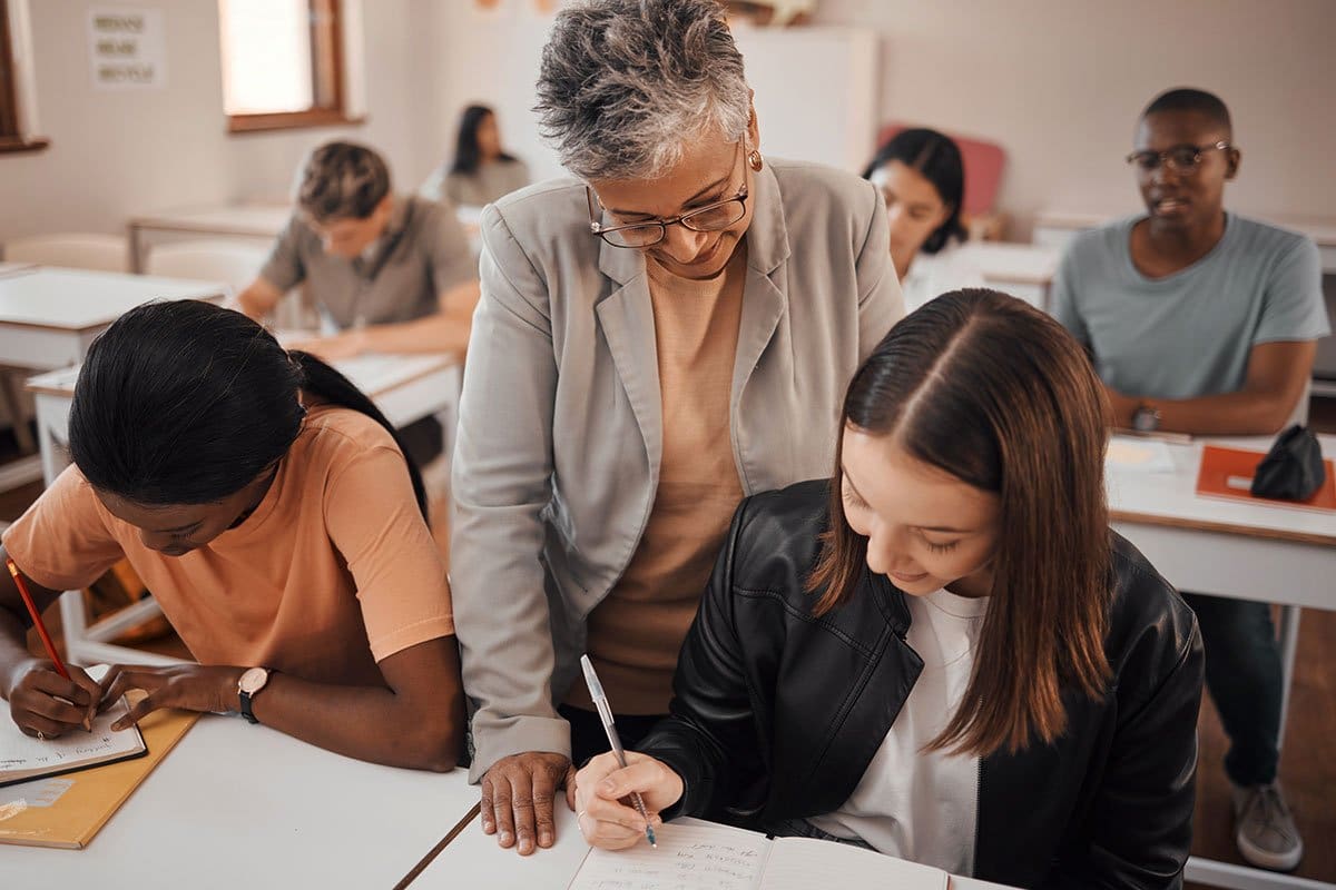 19 Best Businesses to Start in Florida 10 Well-dressed older woman tutor monitoring students during an in-person tutoring session hosted in a classroom