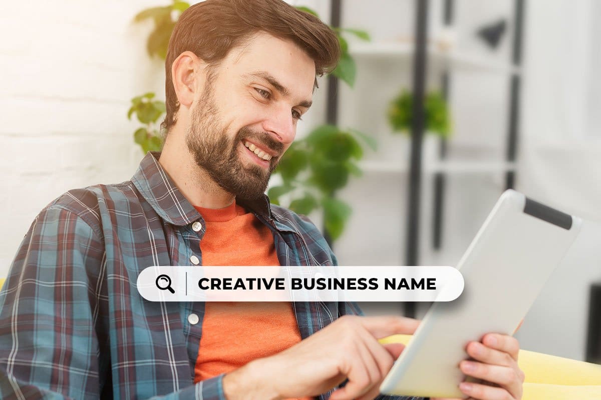 Casually dressed man using a tablet to search for creative business names