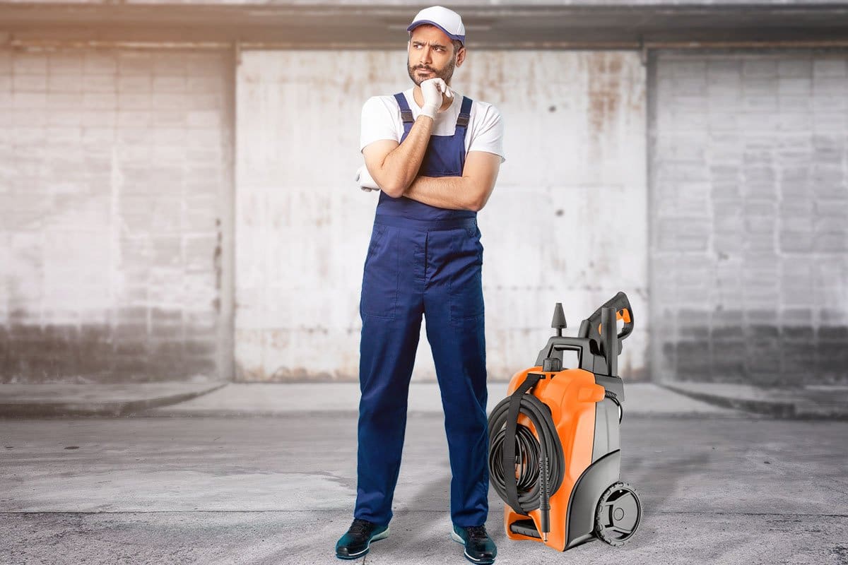 Pressure washing franchise employee standing next to a pressure washer in an underground garage