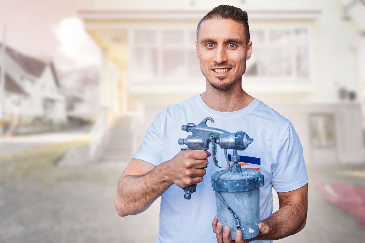Spray-Net owner holding a power sprayer in front of a residential home