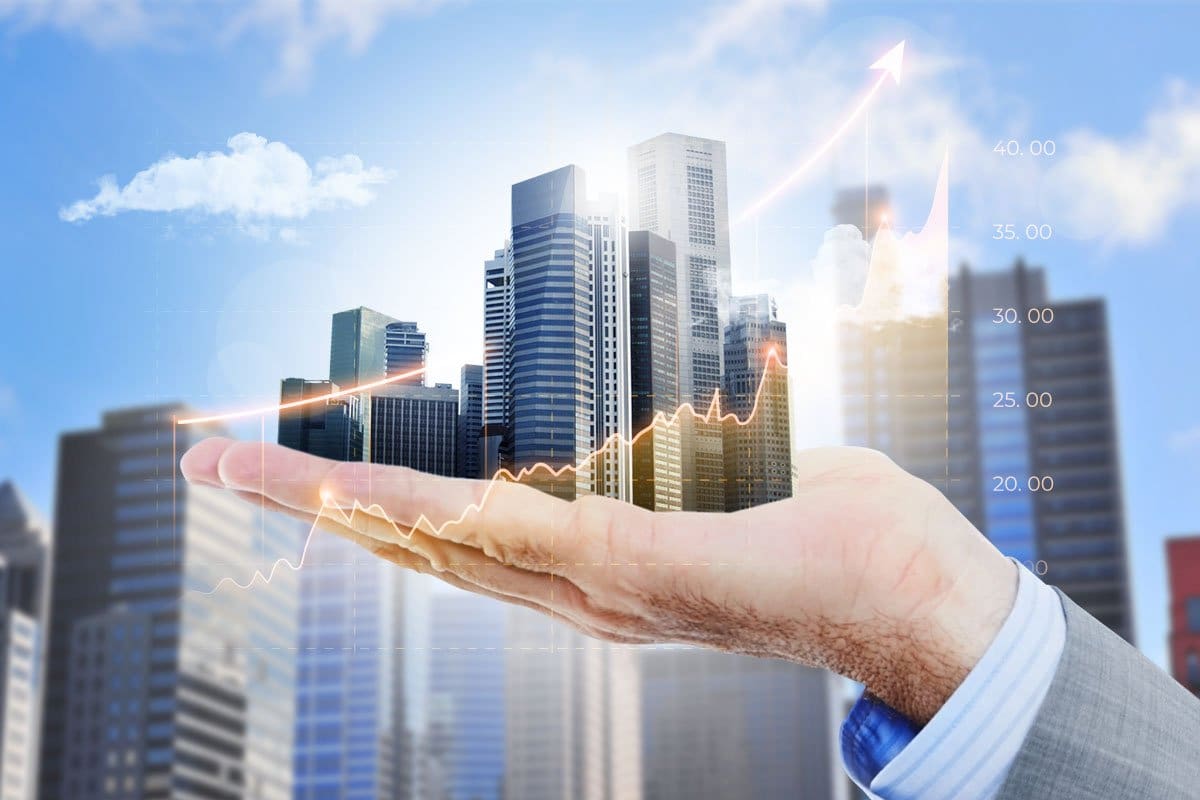 Concept of a businessman holding a cityscape in the palm of his hand.