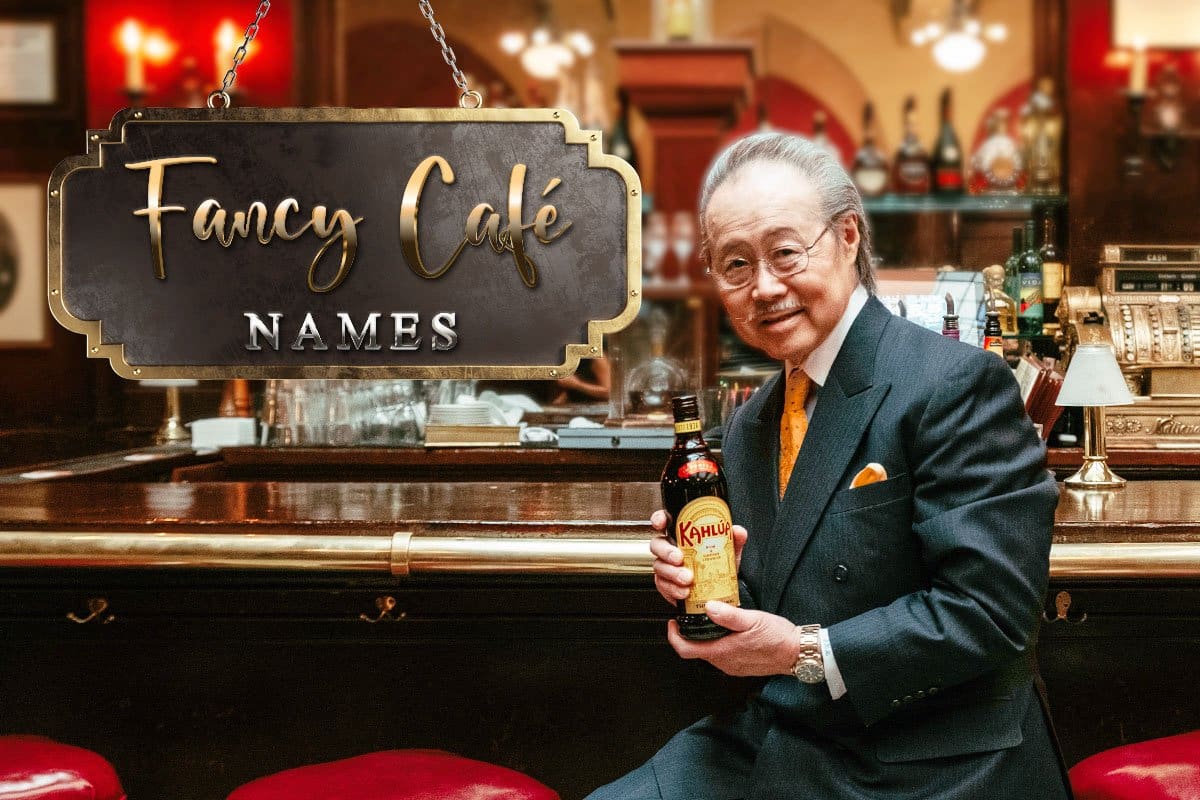 466 Restaurant Name Ideas You’ll Love (2025) 4 Older man in a suit at a cafe bar holding a bottle of Kahlua with a sign that reads "Fancy Cafe Names" hanging over the bar