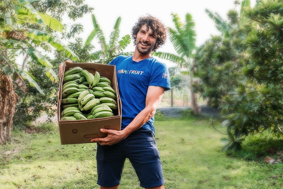 Miami Fruits owner holding a box full of plantains