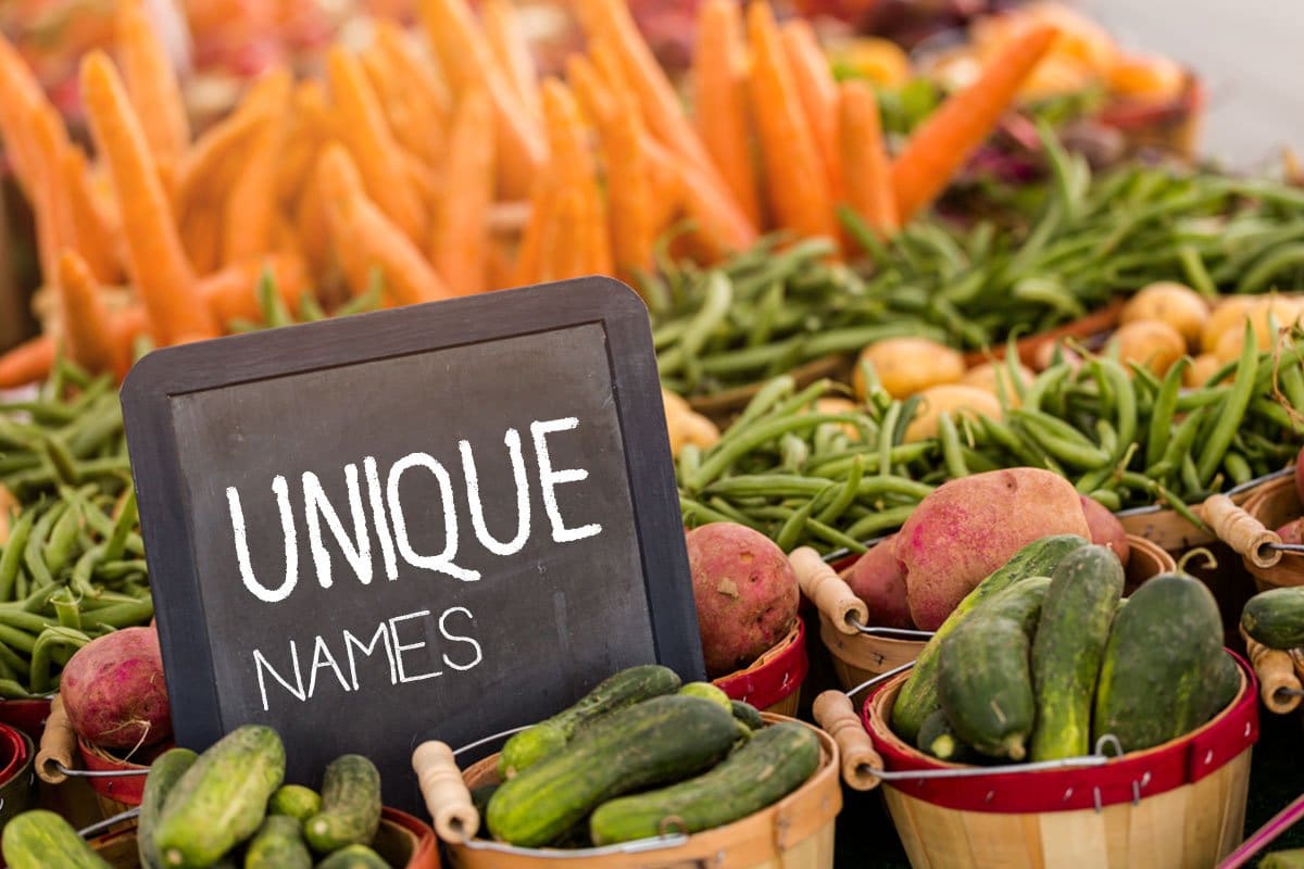Wooden baskets full of produce with a chalk board sign that reads "unique names" situated among them