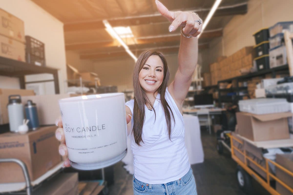 520 Candle Company Names (for 2025) 1 Rx Los Angeles owner in her warehouse pointing to a just-poured wax candle in a branded glass