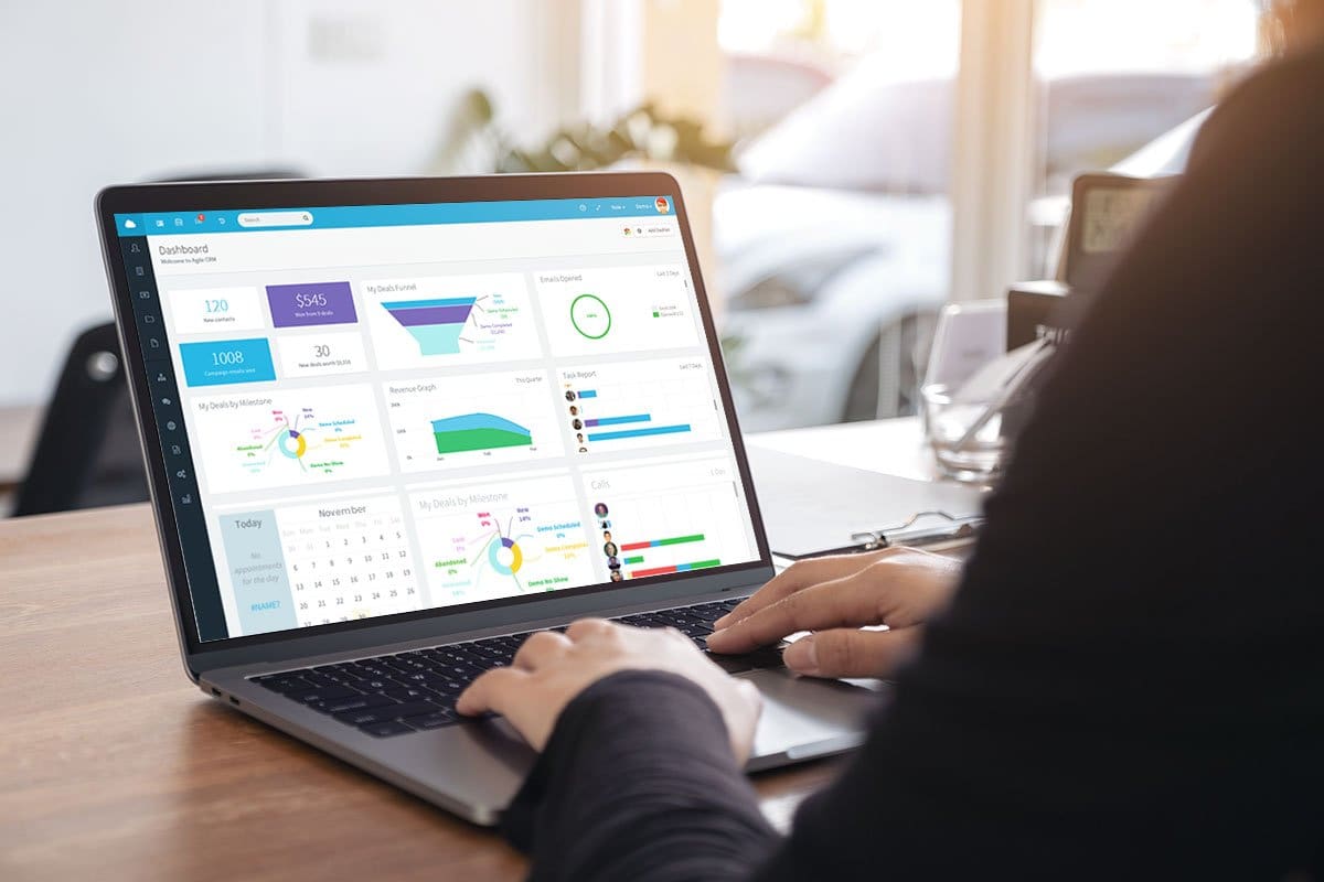 Woman logging into a sales dashboard on her laptop