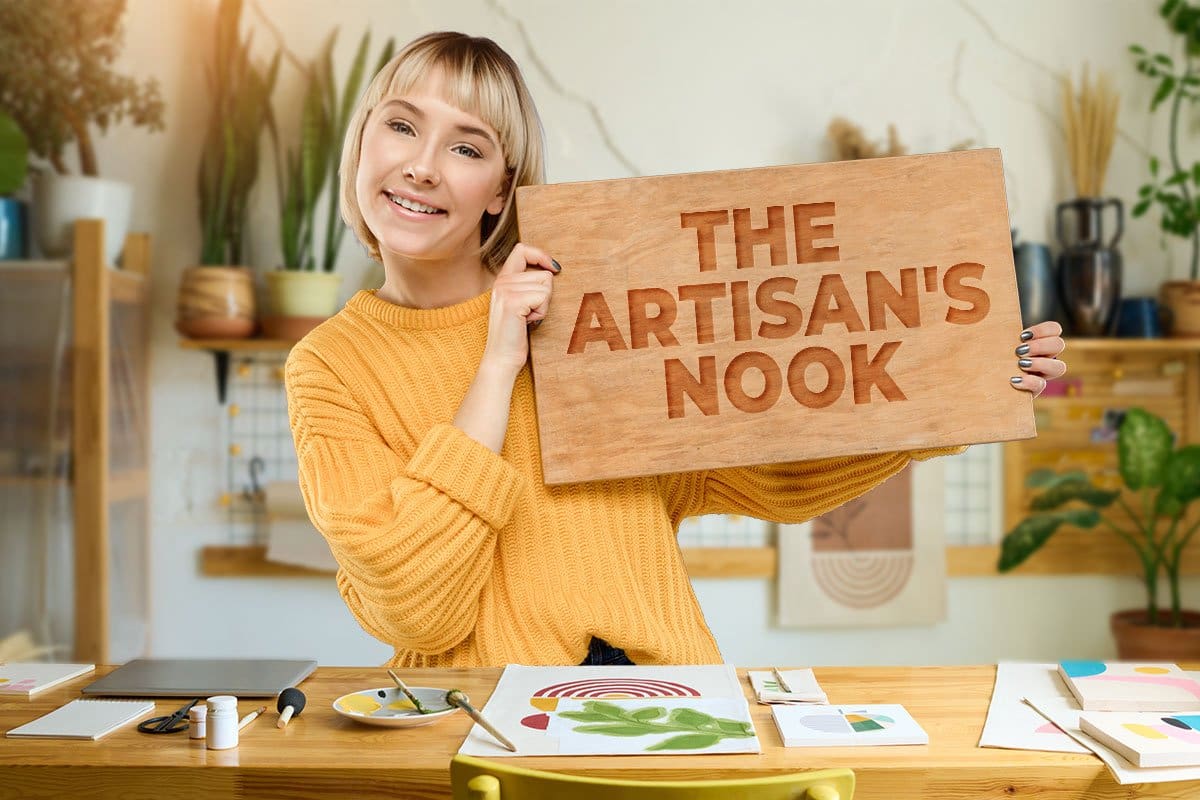 437 Stand-Out Craft Business Names 2 Painter holding a wood sign that reads "The Artisan’s Nook"