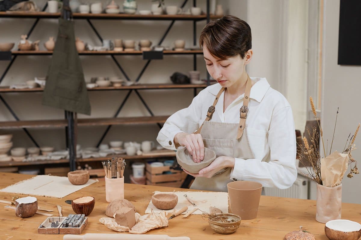 Potter making a pinch pot in a ceramics studio