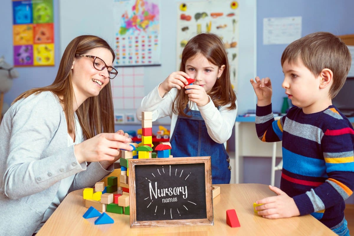 698 Endearing Daycare Names (2025) 7 Nursery school teacher and two children playing with brightly colored wooden blocks at a table with a chalk board sign that reads "Nursery names"