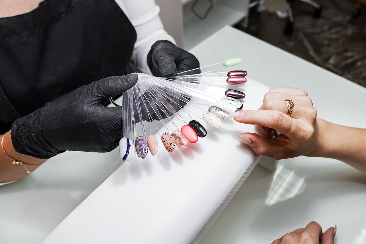 406 Creative Nail Salon Names (2025) 5 Nail salon client picking out a manicure color