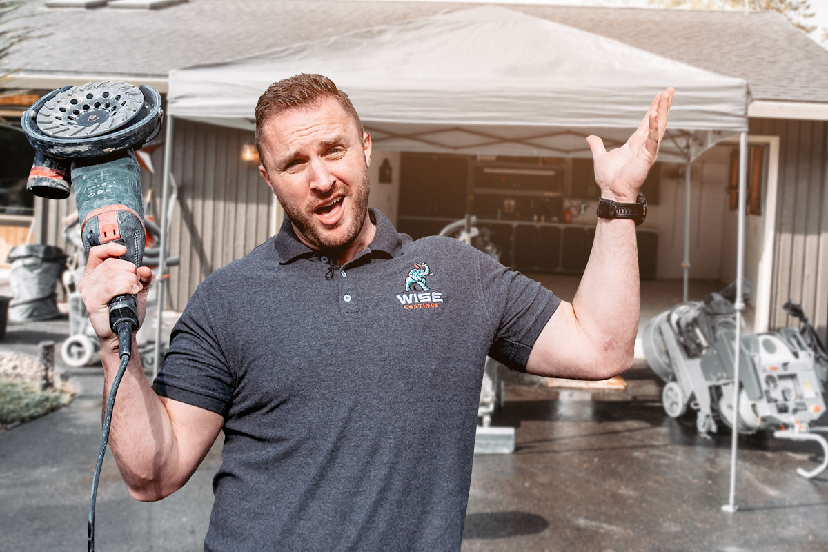 Wise Coatings owner posing with power tools in front of a garage.
