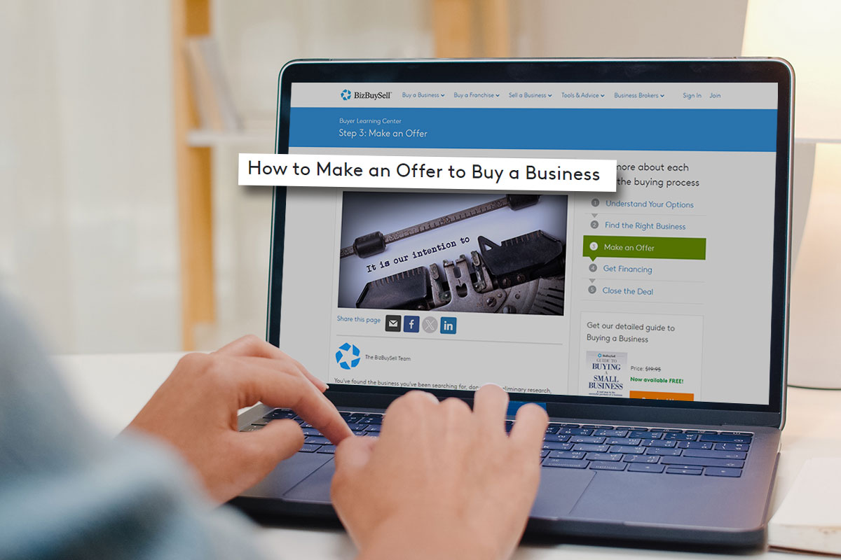 Business person reading a BizBuySell article on how to make an offer to buy a business on their laptop