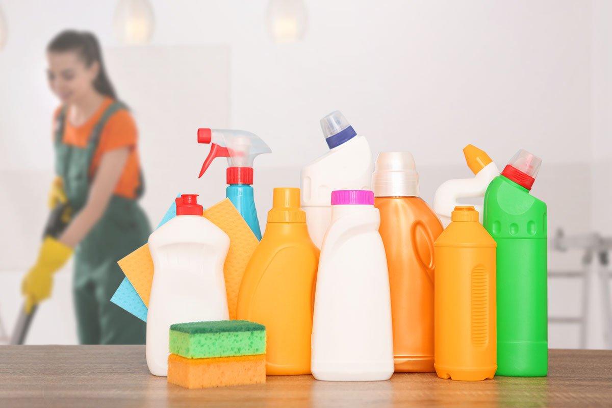 The 16 Best Cleaning Franchises to Own in 2025 4 Cleaning solutions and a sponge in the foreground and a residential cleaner in the background