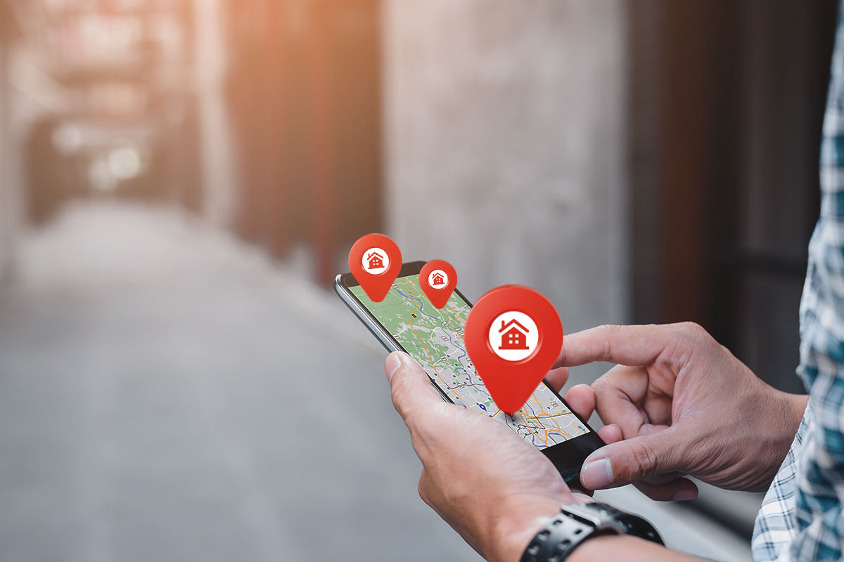 A business owner using a smart phone to look at potential property locations on a map app.