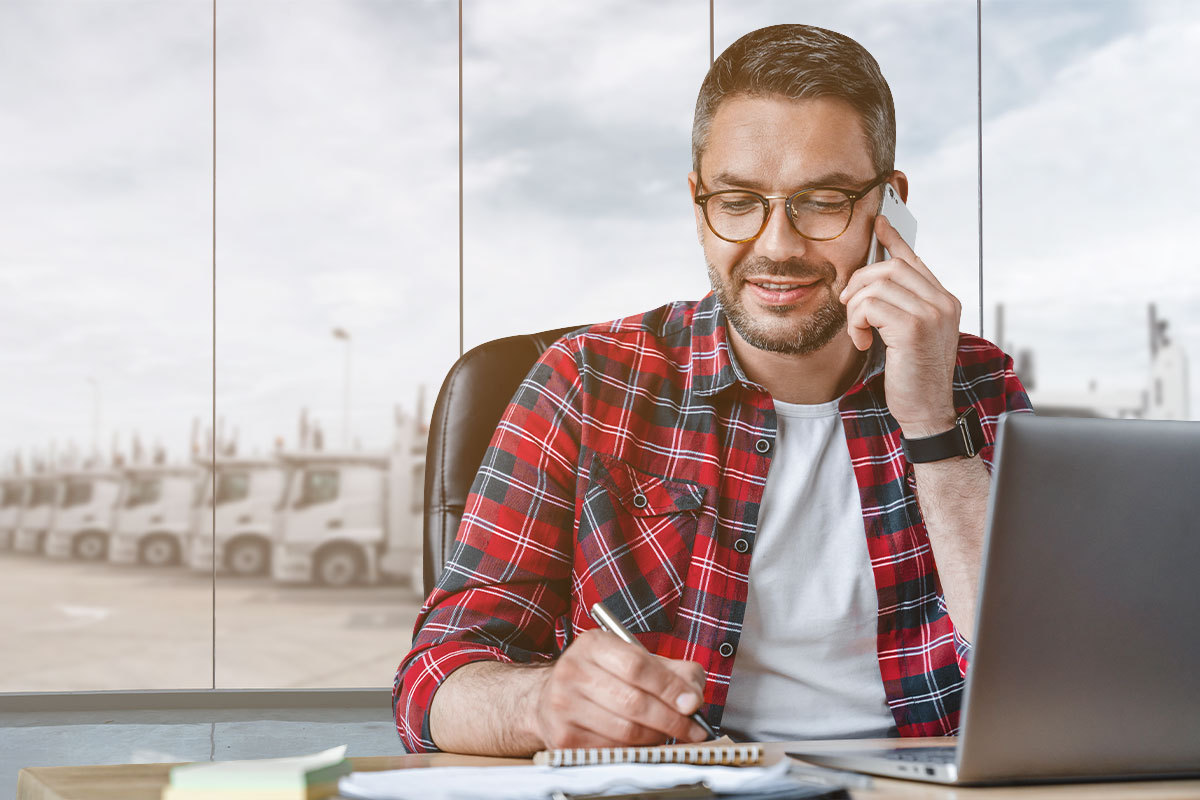 Man using a mobile phone while writing