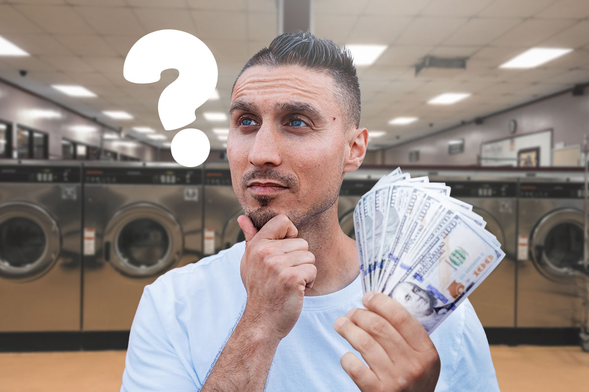 Best Laundromat Franchises of 2025 11 Person holding hundred-dollar bills while thinking about buying a laundromat