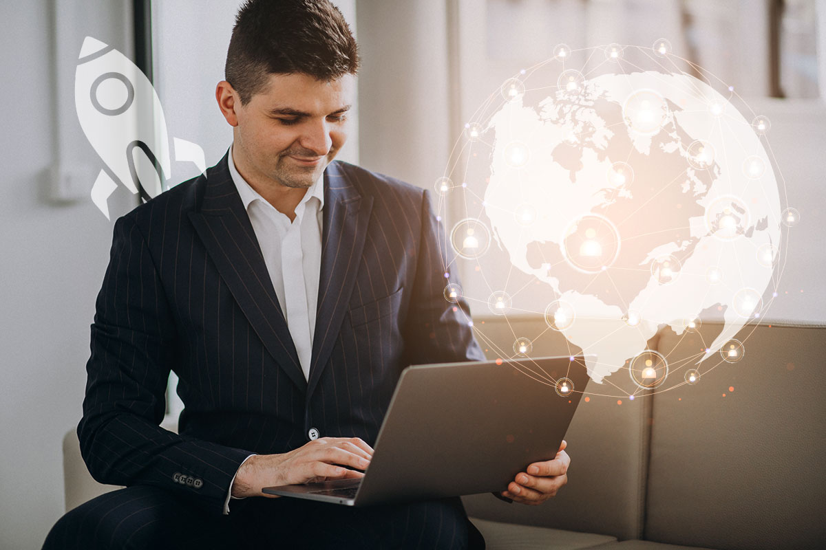 Businessman on a laptop with a cartoon rocket and a globe floating in the background