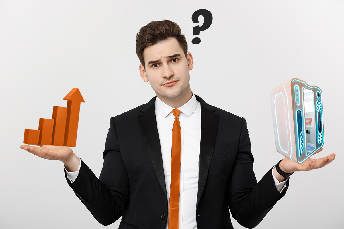 Businessman balancing profit in one hand with a photo booth in the other