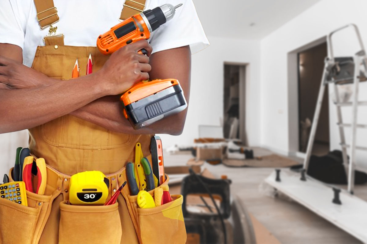 Handyman with drill and hand tools at a residential job site